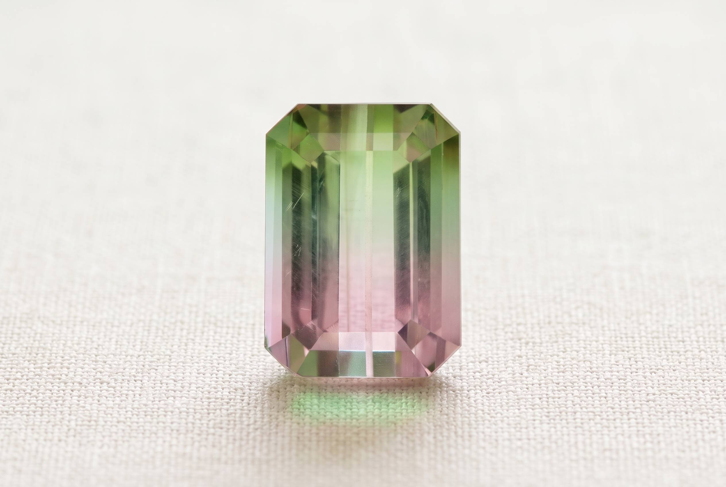 Faceted bi colour tourmaline showing sharp pink to green zoning under even daylight