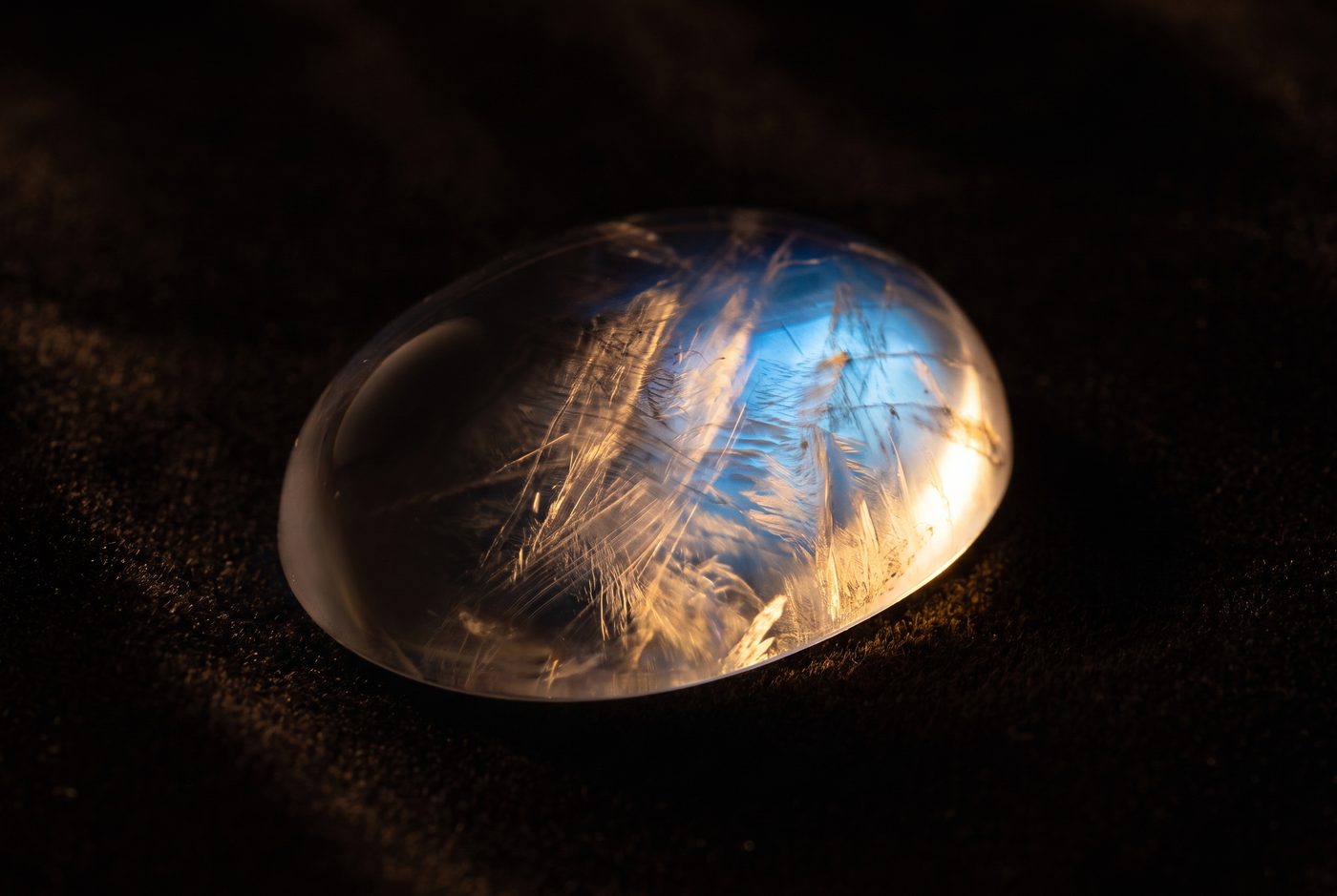 Macro view of moonstone interior revealing fine silk-like and feathery inclusions under light