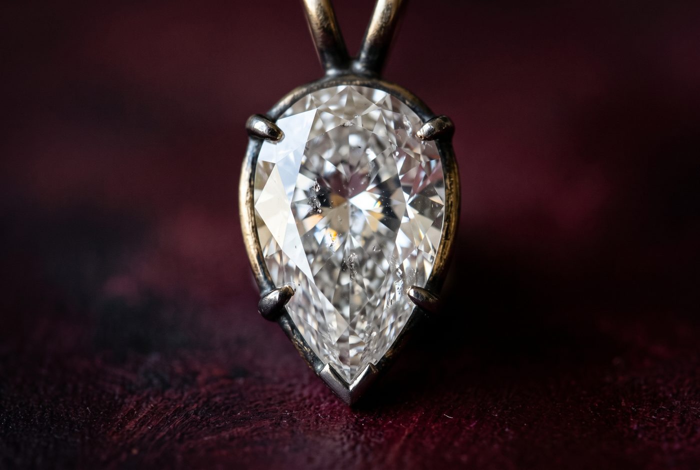 Macro of a pear-shaped gemstone girdle and point showing thin edge, dark background