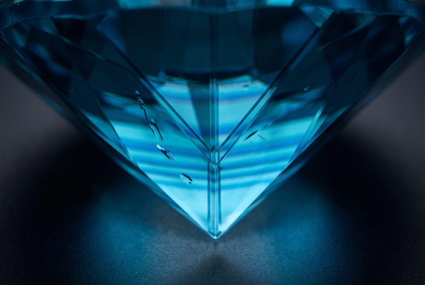 Loupe view of blue zircon showing facet edge doubling and faint colour zoning