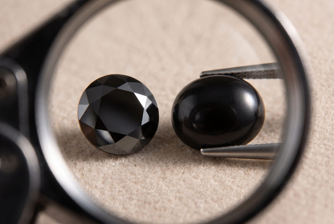 Loupe view of two black gemstones showing contrasting adamantine and waxy surface luster