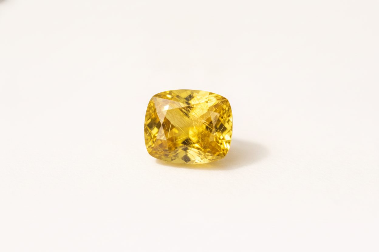 Macro view of yellow tourmaline showing fine needle-like rutile inclusions under bright fibre light